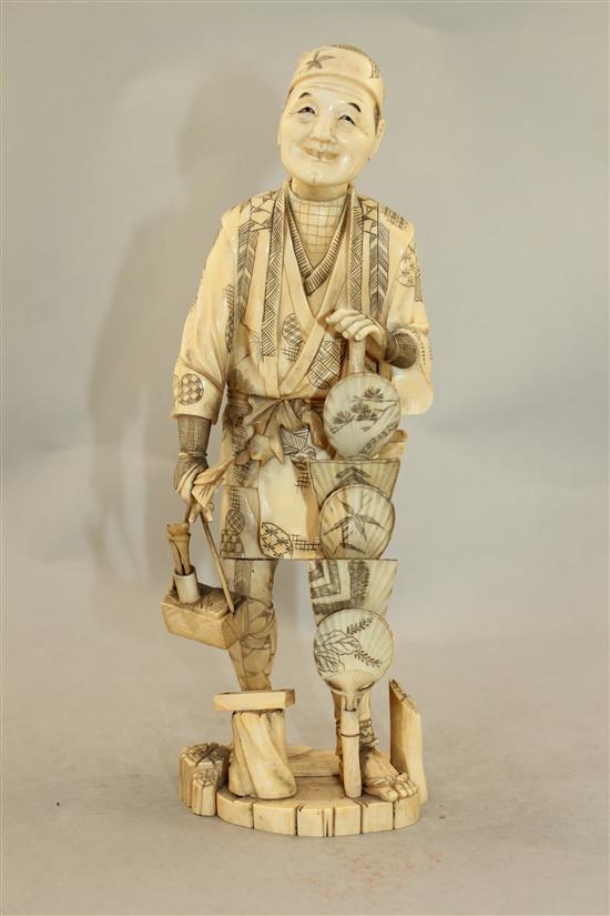 A Japanese sectional walrus ivory figure of a fan seller, early 20th century, 27.5cm